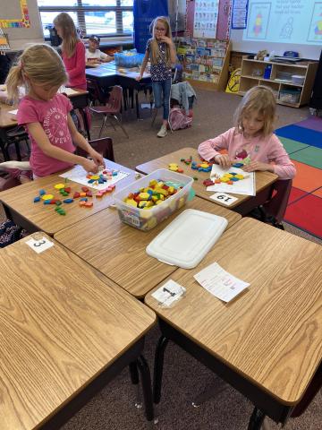First grade students concentrating on their 2D shape pictures