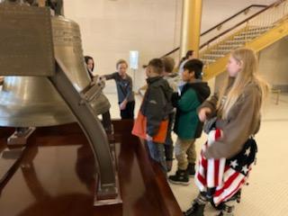4th graders looking at a bell