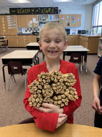 2nd grader showing off 1,000 stick bundle