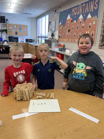 All three 2nd graders together with their final count of 1,080 craft sticks in one box. 