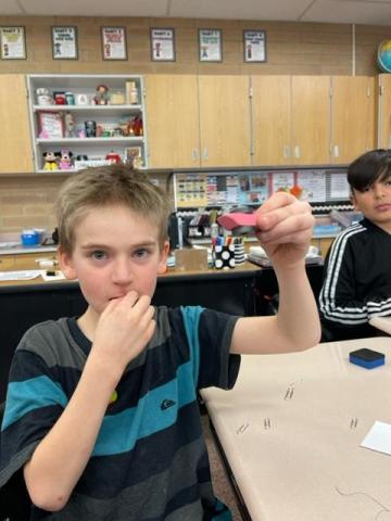 3rd grader using an eraser between two magnets