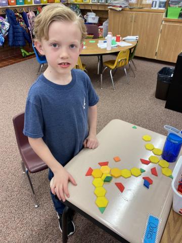 First grader using his shapes to create a bird