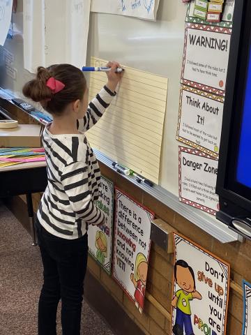 A first grader practicing her writing skills