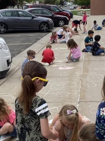 First graders creating sidewalk chalk art