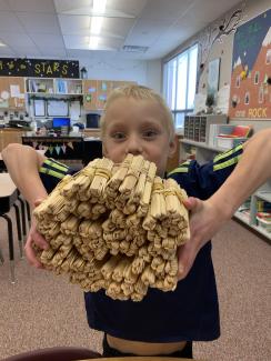 2nd Grader holding 1,000 craft sticks