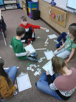 3rd graders working in a group to measure their pictures
